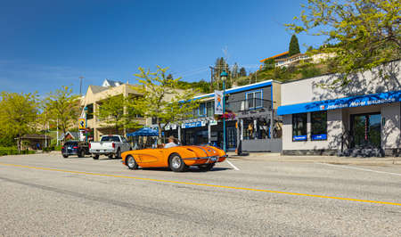 An orange 1959 Chevrolet Corvette Convertible driving in a town. front view. Vintage Chevrolet Corvette a classic cabrio car-June 7,2022-Peachland BC Canada-Travel photo, antique cars conceptのeditorial素材