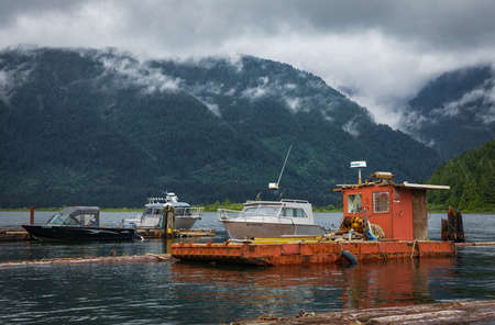 Docked fishing boats in overcast day. Motor boats at the pier in the sea at moody weather in Canada...
