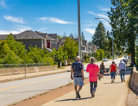 People walking on street walkway on a sunny summer day. Urban neighborhood in summer day. Elderly people on a walk. Street photo, selective focus-June 24,2022-Vancouver BC Canadaのeditorial素材