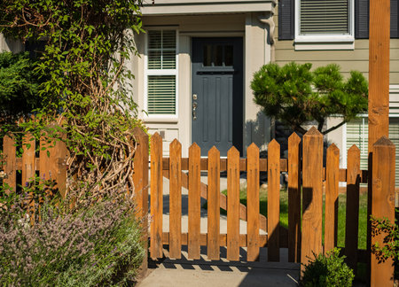 Entrance to a home through a beautiful green garden with flowers, plants leading to entrance of a...