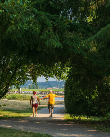 Senior couple in the park on a summer day. Mature couple jogging and running outdoor. Healthy lifestyle and active aging concept. street photographyの写真素材