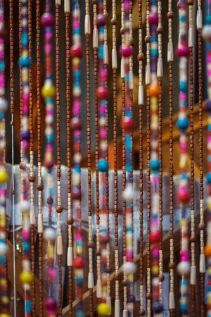 Fragment of a curtain of a plastic beads. Old wooden curtain of beads in the kitchen. Nobody, blurred, selective focusの写真素材