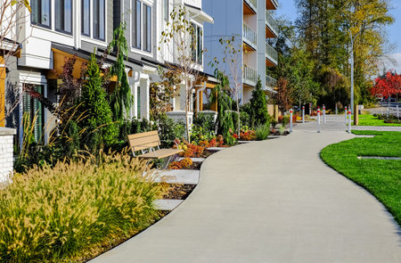 Quiet residential area under the blue sky. Green city street with walkway in residential area in sunny summer day. Street photo, nobody, selective focusの写真素材