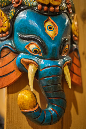 The Wooden of ganesha isolated on wooden background. Colorful Tradition wooden masks and handicrafts on sale at shop. Nobody, blurred, selective focusの写真素材