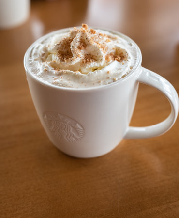 Starbucks coffee caramel latte white mug in Starbucks Cafe. Starbucks is the largest coffeehouse company in the world-Vancouver BC Canada-December 2,2022. Nobody, blurred, selective focusのeditorial素材