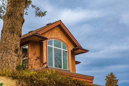 Dormer in the blue sky background. Beautiful Home Exterior. Real Estate Exterior Front House in a...