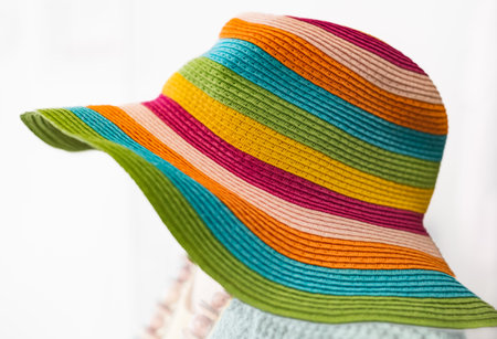 Straw multi-color summer hat on white background. Elegant hat with wide margins. Women beach, colorful stripped hat. Stilish beautiful straw hat for women. Nobody, copyspace for textの写真素材