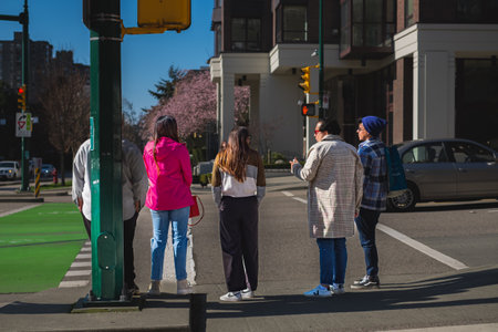 People waiting for the green traffic light in the modern architecture area at Vancouver Canada....