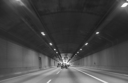 Car rides through the tunnel point-of-view driving. Driving-motion blur tunnel light. Interior of an urban tunnel with traffic. Selective focus, nobody, copyspace for textの写真素材