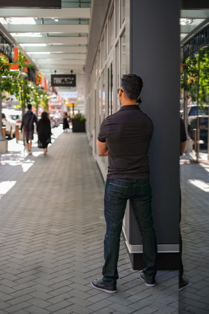 Young man talking on cell phone on the street of city. phone man talking on smartphone. back view. Technology mobile cellphone, smartphone use fast internet connectionの写真素材