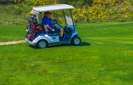 Golf cart or golf club cars in a beautiful golf course with men driving. View of golf cart at golf course. Golf sport concept. Copy space, selective focus, editorial-Vancouver Canada-May 10,2023のeditorial素材