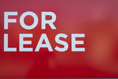 Sign of Lease on red background. For lease sign on a board. Leasing sign promotes the rental property on the street. Nobody, street photoの写真素材
