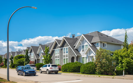 A perfect neighborhood. Houses in suburbs at summer in the north America. Real Estate Exterior Front Houses. Big custom houses with nicely landscaped front yard in the suburbsの写真素材