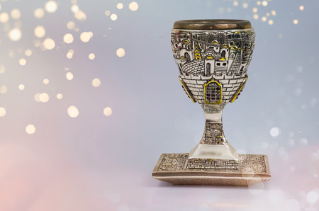 Decorative Silver kiddush wine cup and saucer isolated. Shabbat silver kiddush cup. Kiddush cup with the gemstone of 12 tribes of Israel. Selective focus, copyspace, nobodyの写真素材