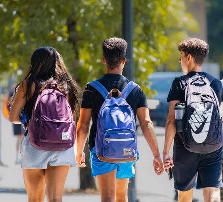 Group of university students walking on a street with the school backpacks. college friends walking together. Young college friends talking and walking. Surrey, Canada-July 20 2023のeditorial素材