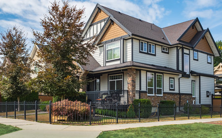 Real Estate Exterior Front House on a sunny day. Big modern custom made luxury house with nicely landscaped front yard in summer. Beautiful house entrance with a green lawn. Perfect neighborhoodの写真素材