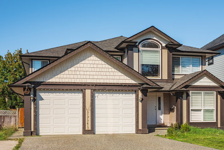 Detached house with double garage. Big family house with double size garage. Residential house with concrete driveway and entrance door. Custom built luxury house in a residential neighborhood