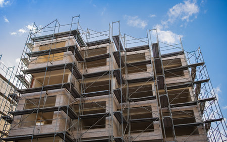 Construction site of modern apartment building. Workers are working on construction site with...