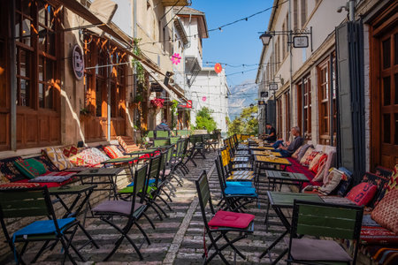 Outdoor empty coffee and restaurant terrace with colorful tables and chairs. Old fashioned cafe terrace in Berat Albania. Restaurant patio furniture. November-9,2023のeditorial素材