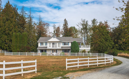 Old farmhouse in the farmland of rural. Typical North American Country Farm House on sunny day. Farm yard with the plowed field in front. Travel photo, selective focus, nobodyの写真素材
