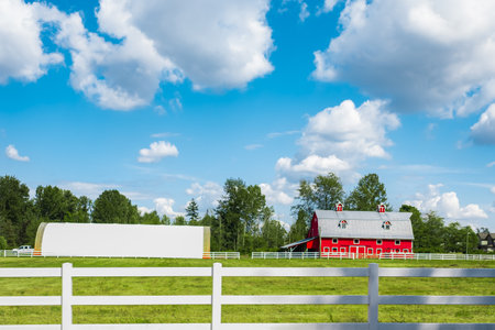 North American Farm country house in the field with fence. Rural Farmhouse with barns on a sunny day in a summer. Agriculture Landscape With Red Barn. Countryside landscape. Rural scenery, farmlandの写真素材
