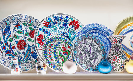 Variety of colorfully hand painted plates for sale at a market. Decorative ceramic plates on a shelf of a store. Collection of colorful ceramic potteryの写真素材