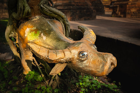 A buffalo statue on the ground in the garden. Buffalo wooden statue on grass, Asian garden, decor. Nobody, selective focusの写真素材