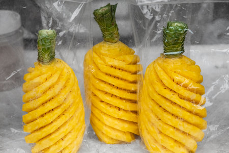 Ripe pineapple peeled in plastic bag selling in local market. Whole ripe pineapple peeled. Nobody, street photoの写真素材