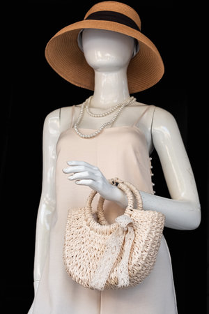 Mannequin wearing floral sundress dress,hat, handbag on a black background. Female mannequin in a beach hatの写真素材