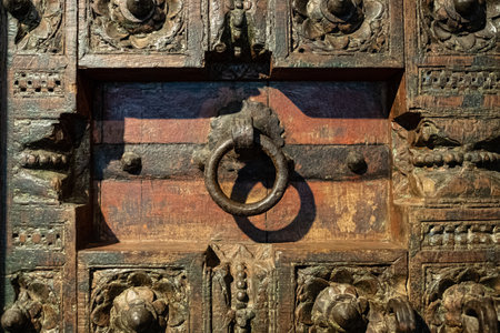 Old knocker door with ring. Aged brass door handles in the form of ring at the timbered ancient weather-beaten door. Old metal door knock handler. Ancient metal handle. Metal gates with ring handleの写真素材