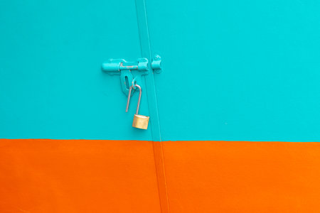 Metal door with Latch and an open Lock. Stainless steel padlock on a green and orange background.
