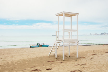 The lifeguard tower on the beach. Wooden Lifeguard chair on an empty beach and overcast cloudy sky, sea in daylight. Travel photo, Copy space.の写真素材