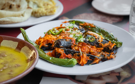 Middle eastern traditional cuisine or Arabic dishes on the table in restaurant. Tasty traditional food. Roasted spicy eggplants and ful with fava beans. Top view, selective focus, nobodyの写真素材