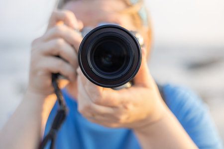 Woman taking picture outdoors with a camera. Soft focus of women photographer holding camera and taking a photo. Closeup, selective focus. blurred. Travel photo, Photography concept.の写真素材