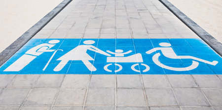 Photo of designated walkway spaces for people with disabilities, featuring clear blue markings that ensure accessibility. Wheel chair, mothers with buggies and old people walkway. Handicap signs. Nobody, copy space.の写真素材