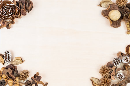Rustic flat lay made of natural materials decor, flowers and fir cones over light wooden table background. Backdrop with copy space, Flat lay, top view, mock up poster frameの写真素材