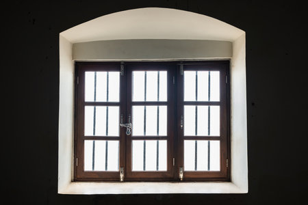 Triple wooden window. Old brown window frame in a vintage house. Threefold wooden window, view from...
