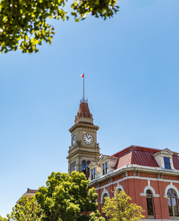 Historic red-brick building Victoria City Hall clock tower under a blue sky in downtown Victoria British Columbia, Canada. Travel photo, nobody, copy space for textの写真素材