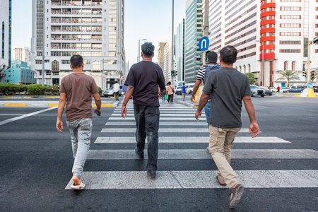 Unrecognizable people crossing street on traffic light zebra. Crowd of people walking on zebra crossing street city center - Rushing hour, urban, city life, business. Pedestrians crossing streetの写真素材