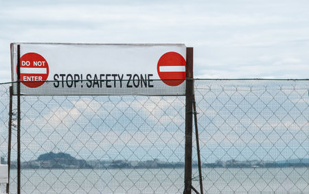 Stop Do Not Enter Sign outdoors in a park. Restricted Area Do Not Enter warning sign attached to a fence. No Trespassing red sign on the side of a private property prohibition passage. Danger unsafe areaの写真素材