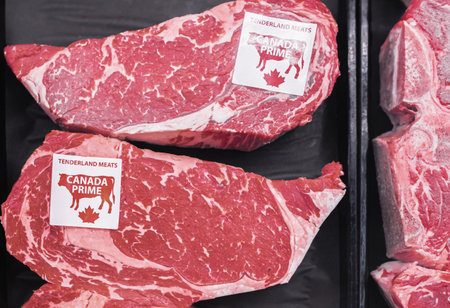Meat Products in Canadian Supermarket. Premium Raw fresh Strip Steaks on the shelf of a meat store....
