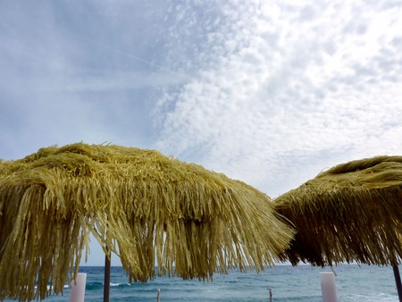 Two yellow sun umbrellas in front of the seaの写真素材