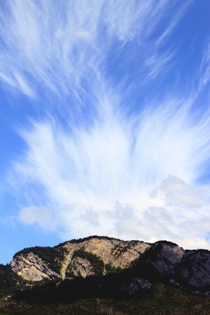 Sunny mountain and big beautiful cloud upon it by beautiful weatherの写真素材