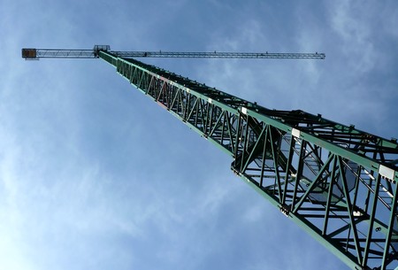Big green crane with a background of a cloudy blue skyの写真素材