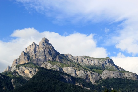 Sunny mountain and big cloud upon it by beautiful weatherの写真素材