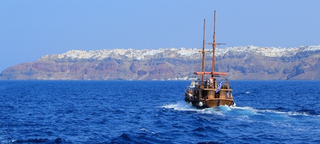Panoramic view of an old tourist boat going to Oia village on the cliff at Santorini, Greeceの写真素材