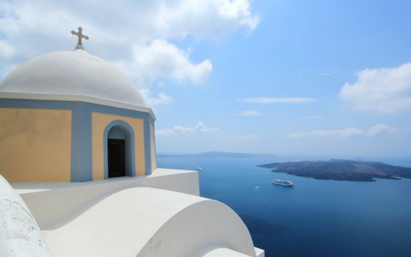 Dome and cross of a greek orthodox church in Santorini island, Greece, by beautiful weatherの写真素材