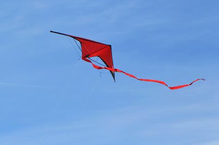 Big red kite flying in the blue skyの写真素材