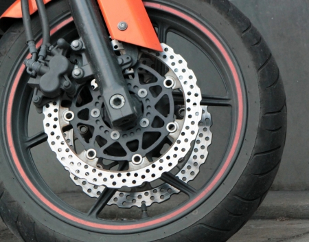 Close up of the front wheel of a red motorbikeの写真素材
