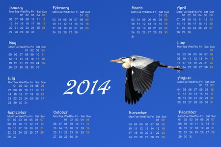 2014 english calendar with great heron flying across a deep blue sky by sunriseの写真素材